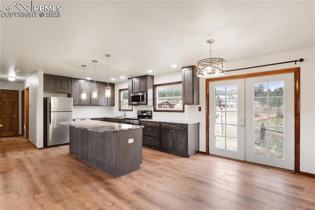 13771 South Hedi Road Sedalia, CO 80135 - Photo 9 of 49 a large kitchen with stainless steel appliances granite countertop a large counter top a stove a refrigerator with cabinets and wooden floor
