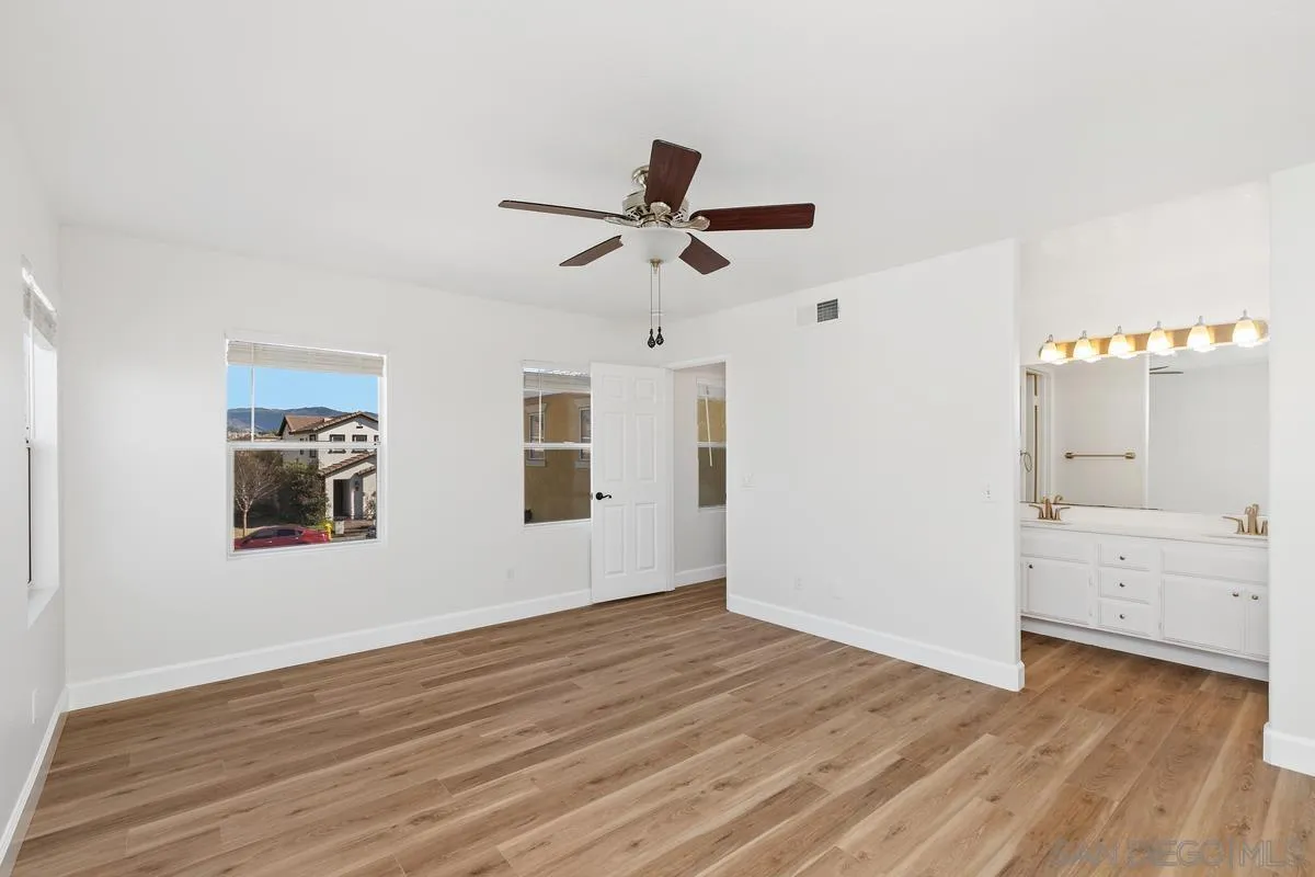 1651 Applegate Street Chula Vista, CA 91913 - Photo 13 of 20 a view of a bedroom with wooden floor and a ceiling fan