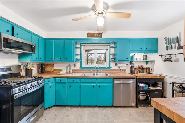 a kitchen with kitchen island a sink stainless steel appliances and cabinets