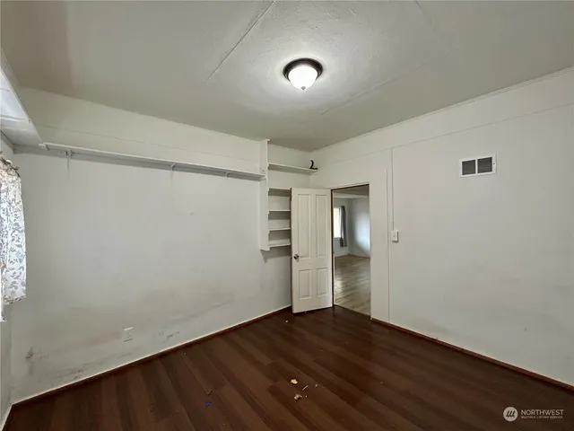 a view of an empty room with wooden floor