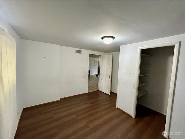 a view of an empty room with wooden floor