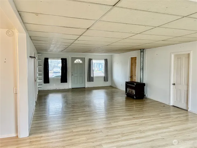 a view of empty room with wooden floor and fireplace