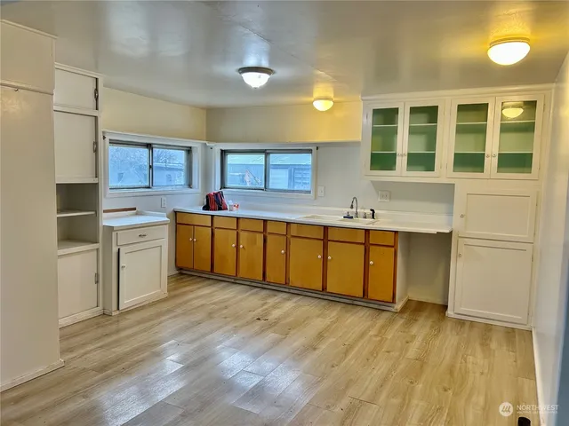 a kitchen with a sink cabinets and wooden floor