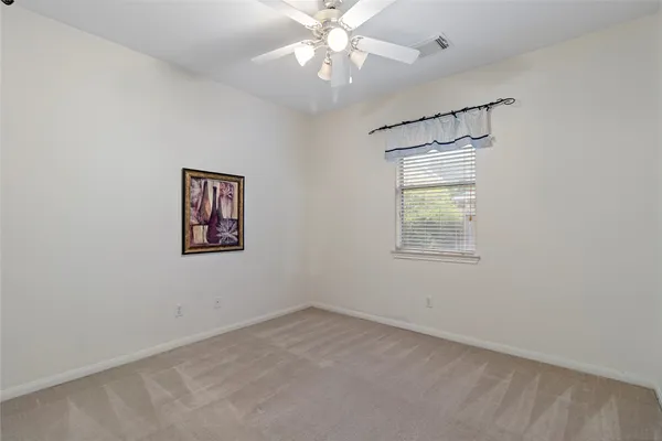 an empty room with a window and a fan