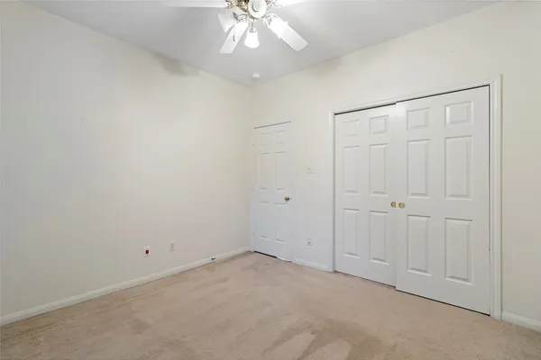 an empty room with a ceiling fan and bathroom