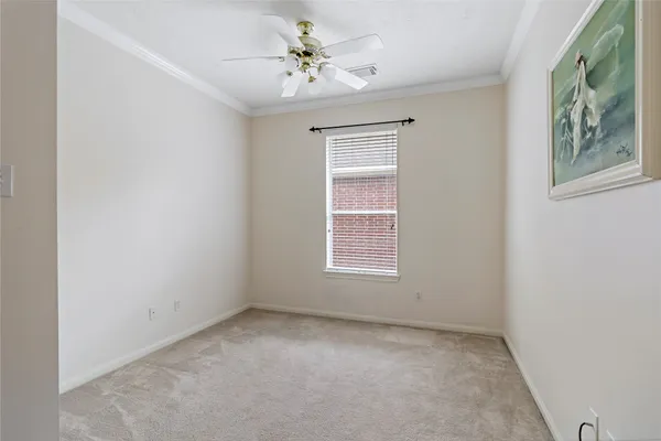 an empty room with windows and ceiling fan