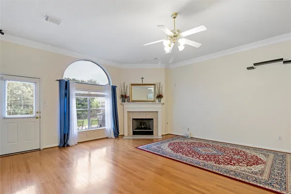 a view of an empty room with window and wooden floor