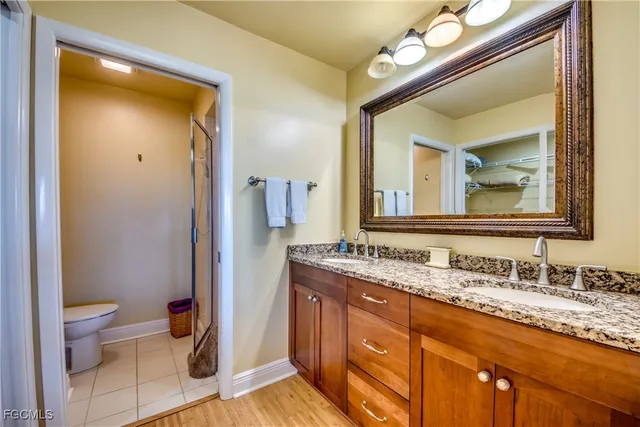 a bathroom with a granite countertop sink toilet and a mirror
