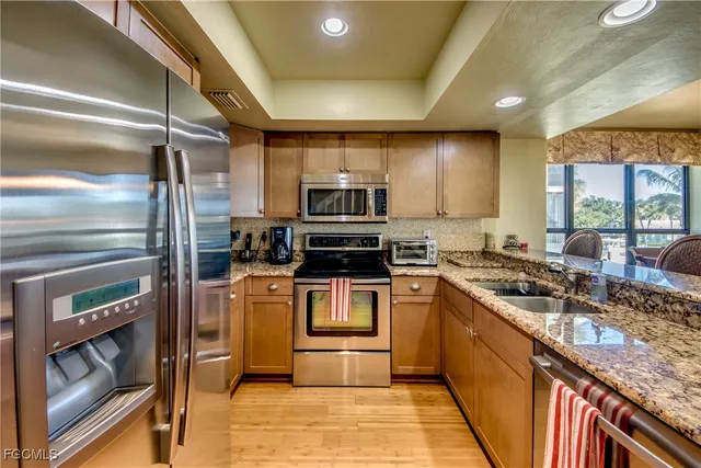 a kitchen with stainless steel appliances granite countertop a stove and a sink