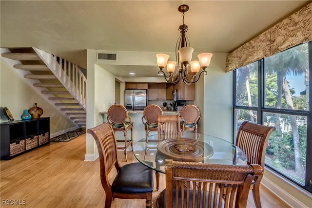 a view of a dining room with furniture a chandelier and wooden floor