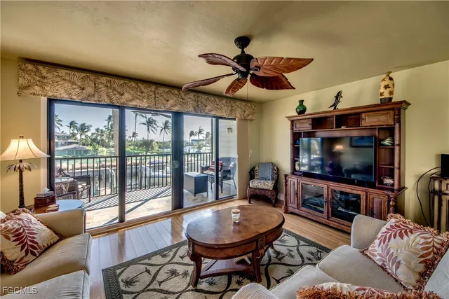 a living room with furniture a ceiling fan and a flat screen tv