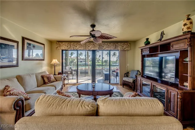a living room with furniture a ceiling fan and a flat screen tv
