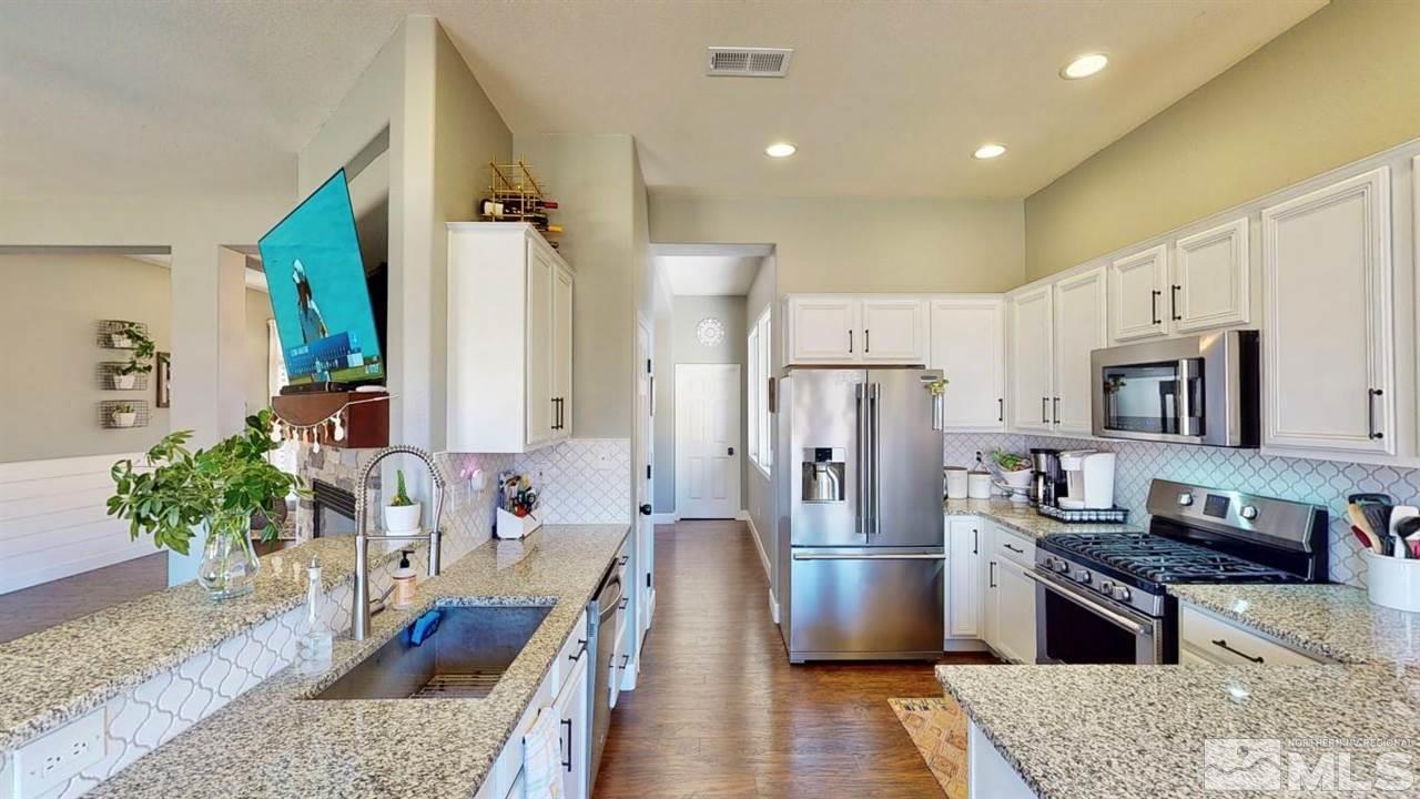 10621 Copper Moon Court Reno, NV 89521 - Photo 14 of 33 a kitchen with stainless steel appliances granite countertop a refrigerator a stove and a sink
