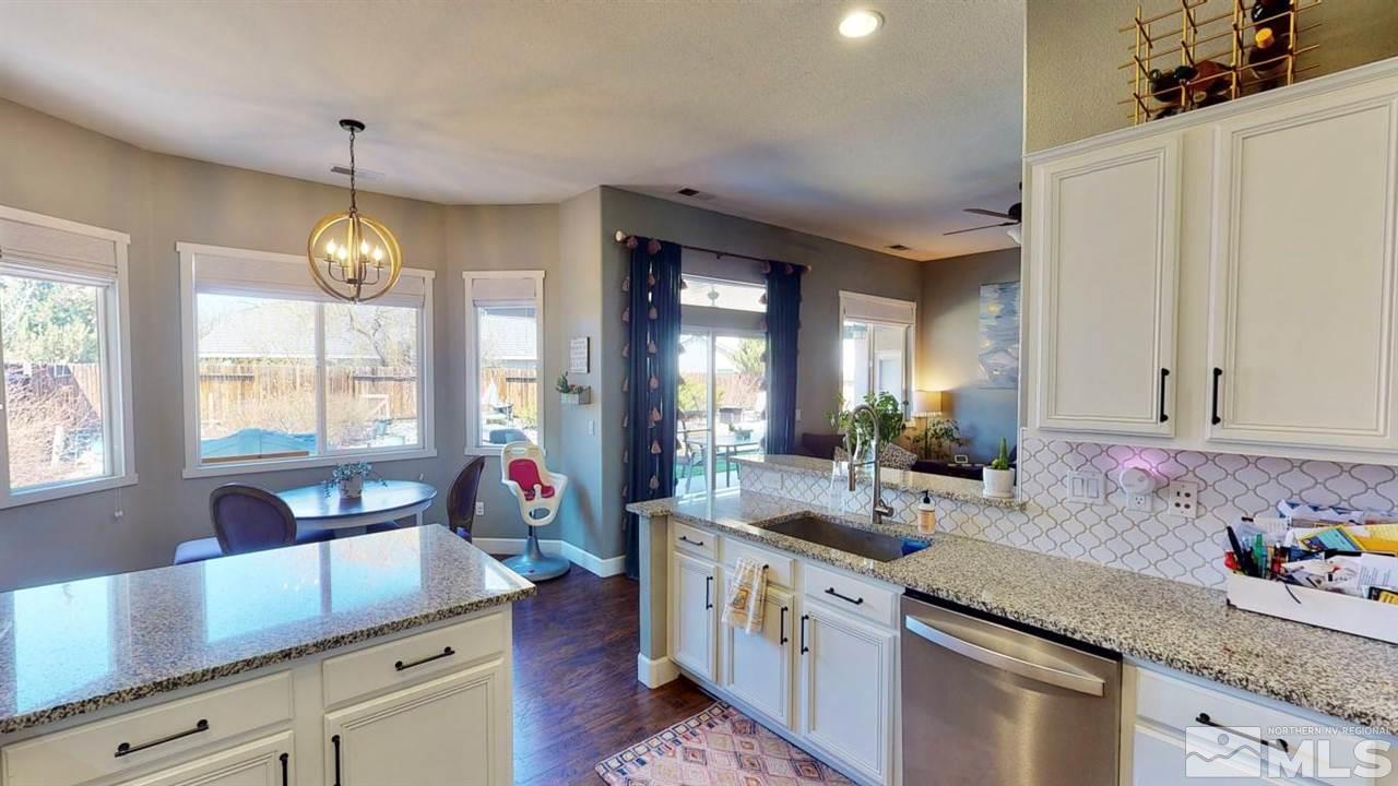 10621 Copper Moon Court Reno, NV 89521 - Photo 15 of 33 a kitchen with granite countertop a sink stove and cabinets