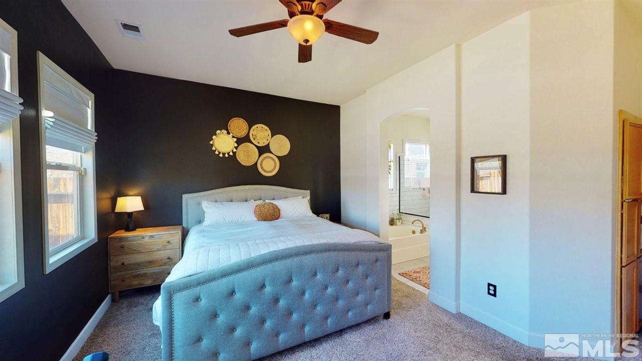 10621 Copper Moon Court Reno, NV 89521 - Photo 24 of 33 a bedroom with a bed and a chandelier