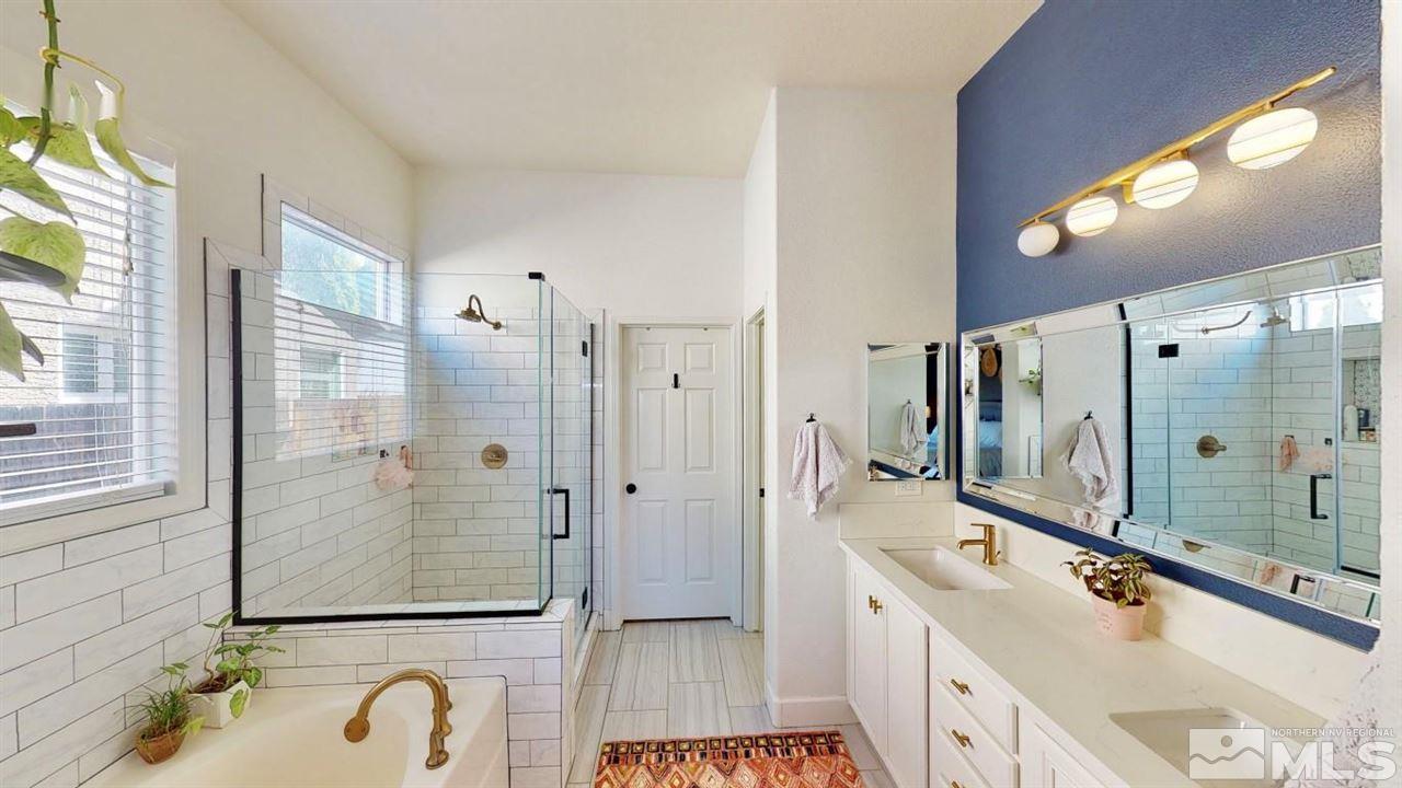 10621 Copper Moon Court Reno, NV 89521 - Photo 26 of 33 a bathroom with a tub a sink shower and mirror