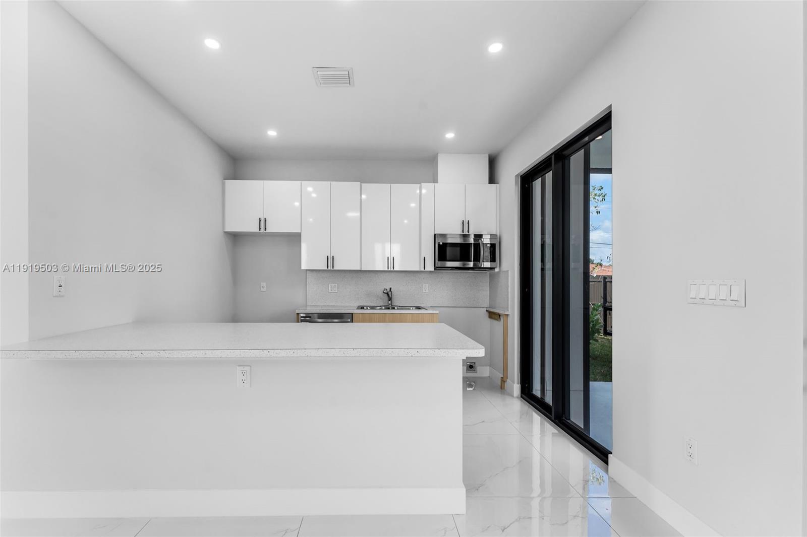 12393 Southwest 220th Street Miami, FL 33170 - Photo 5 of 22 a kitchen with a refrigerator a sink and a stove top oven