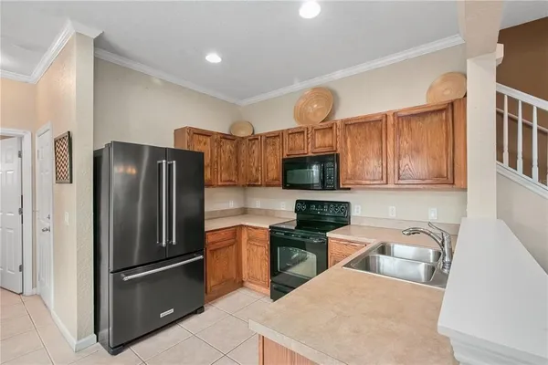 a kitchen with stainless steel appliances granite countertop a refrigerator a stove top oven a sink and dishwasher