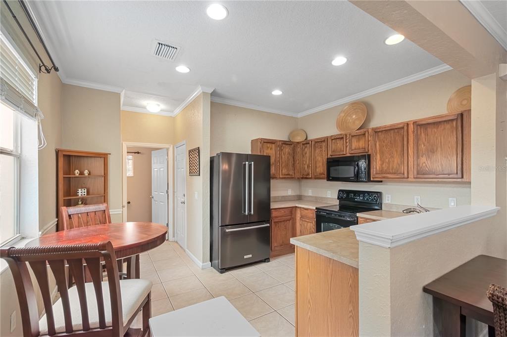 4122 Southwest 54th Circle Ocala, FL 34474 - Photo 12 of 47 a kitchen with stainless steel appliances granite countertop a refrigerator a stove a sink a microwave oven with white cabinets and wooden floor