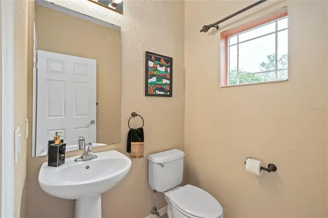 a bathroom with a toilet sink and mirror