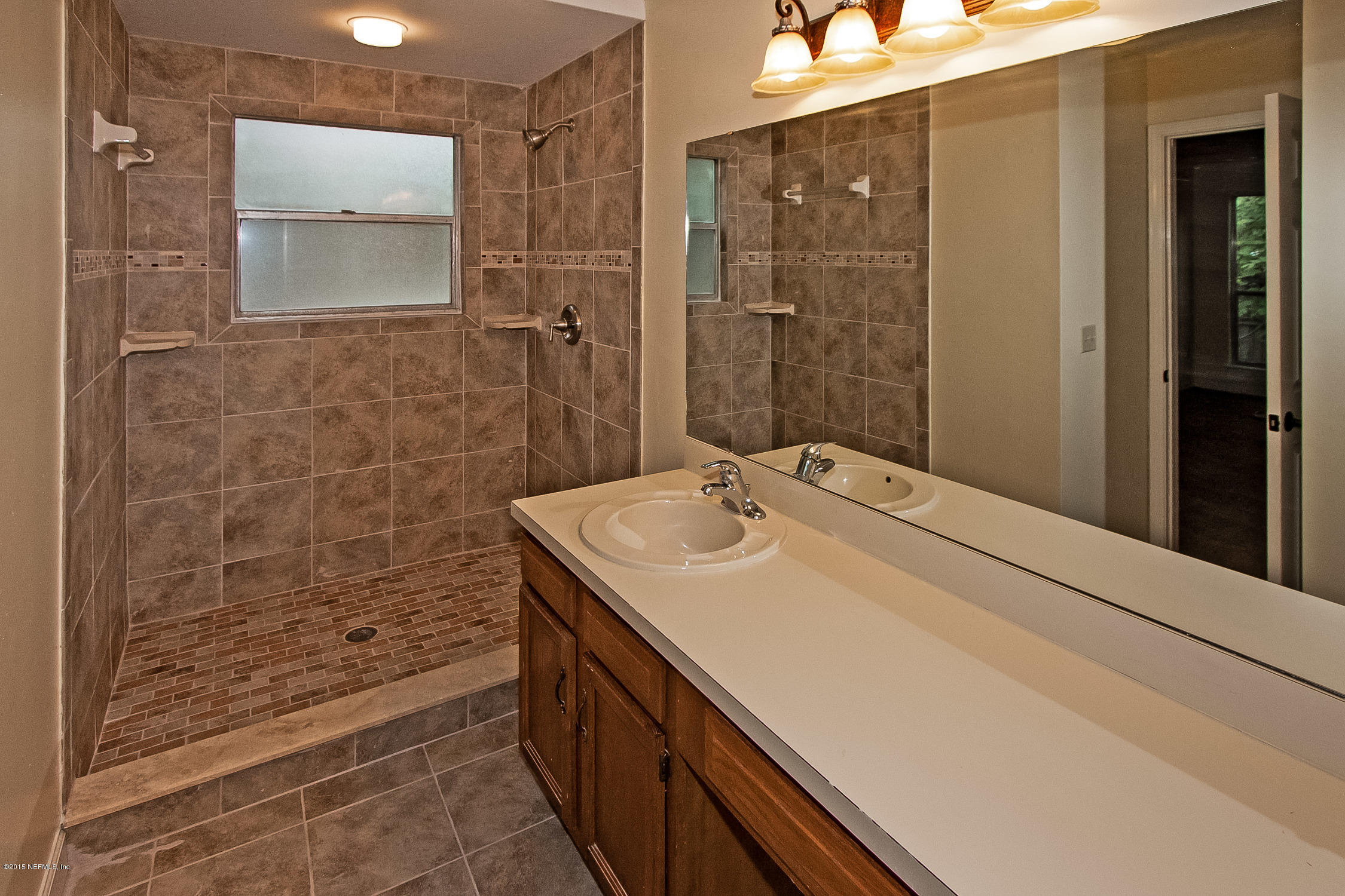 1551 Derringer Road Jacksonville, FL 32225 - Photo 17 of 27 a bathroom with a sink a shower and a mirror