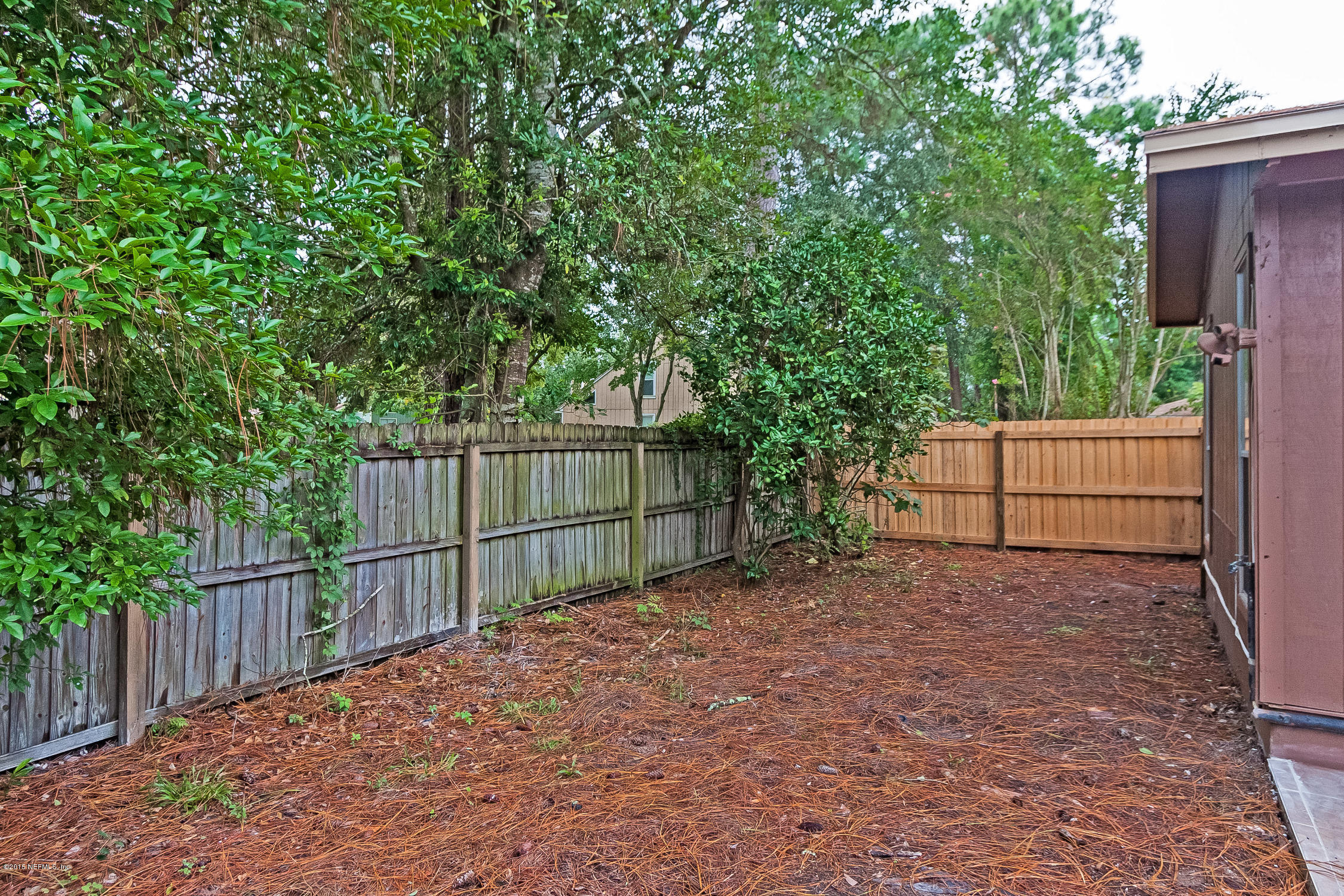 1551 Derringer Road Jacksonville, FL 32225 - Photo 22 of 27 a view of backyard with wooden fence and trees