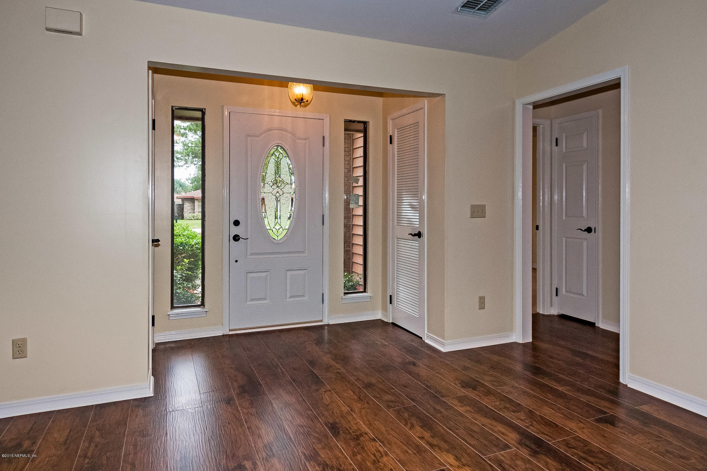 1551 Derringer Road Jacksonville, FL 32225 - Photo 5 of 27 an empty room with wooden floor and mirror