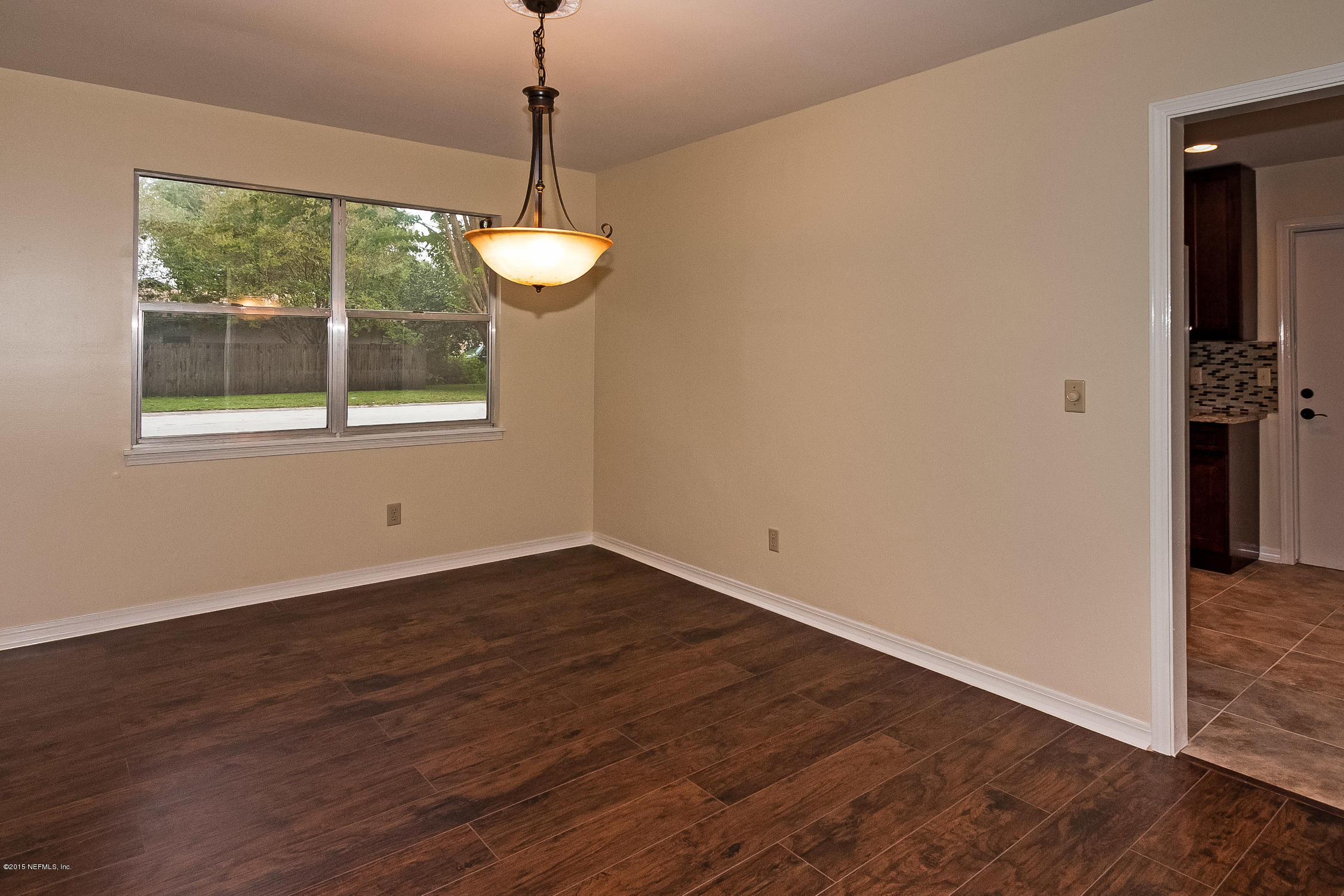 1551 Derringer Road Jacksonville, FL 32225 - Photo 9 of 27 a view of an empty room with wooden floor and a window