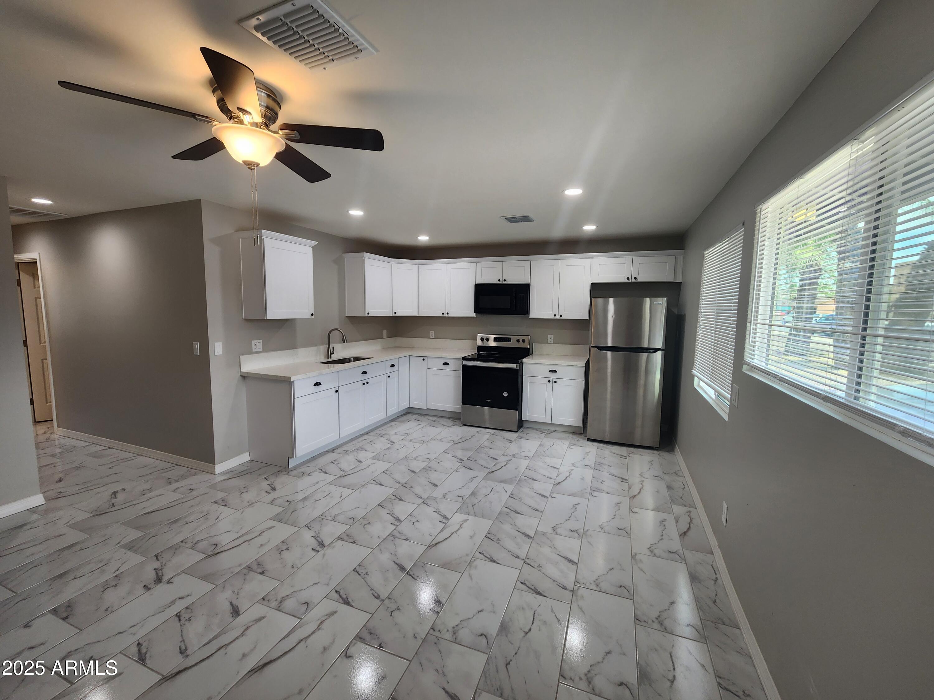 a large kitchen with cabinets and stainless steel appliances