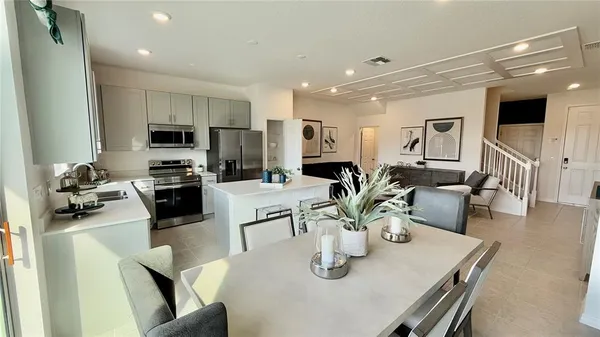 a kitchen with stainless steel appliances granite countertop a sink a stove a microwave a dining table and chairs