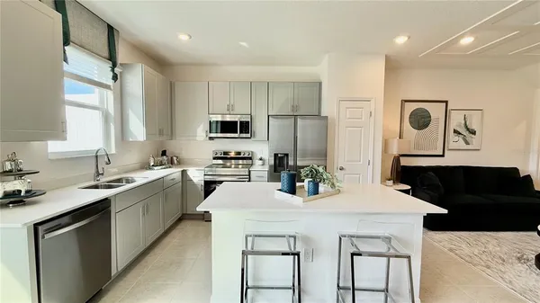 a kitchen with granite countertop a sink stainless steel appliances and white cabinets