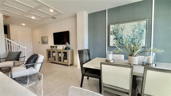 a dining room with furniture and a flat screen tv