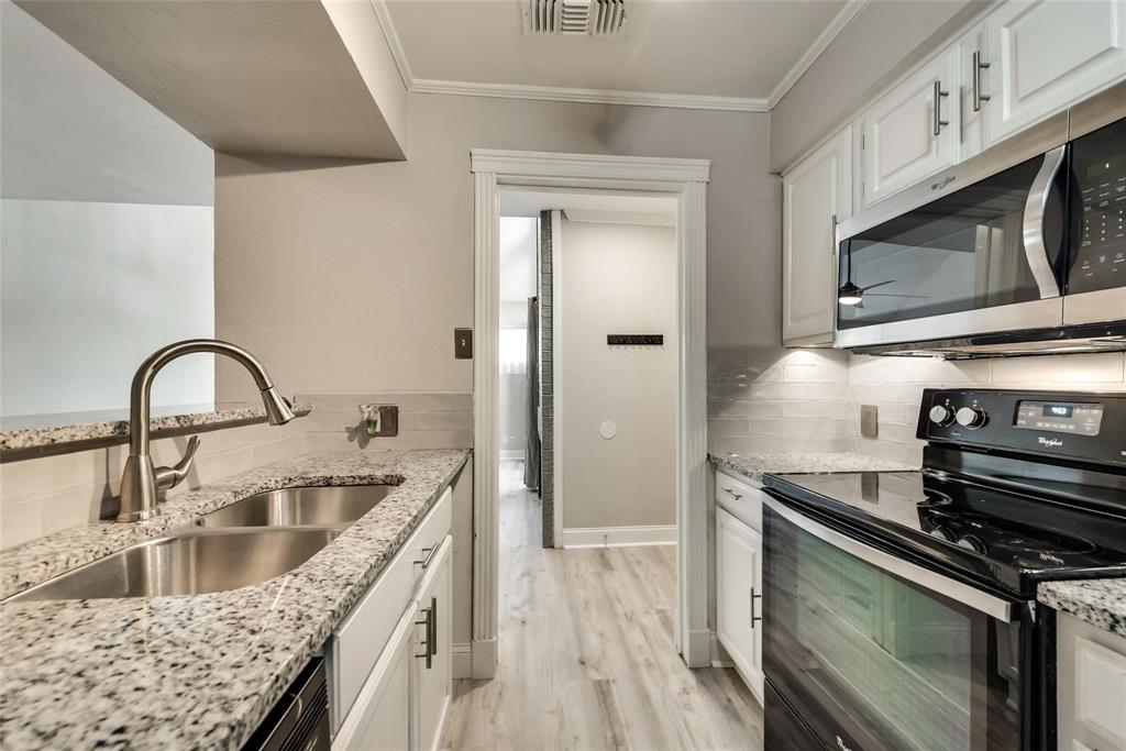 18240 Midway Road, Unit 302 Dallas, TX 75287 - Photo 13 of 33 a kitchen with stainless steel appliances granite countertop a sink stove and microwave