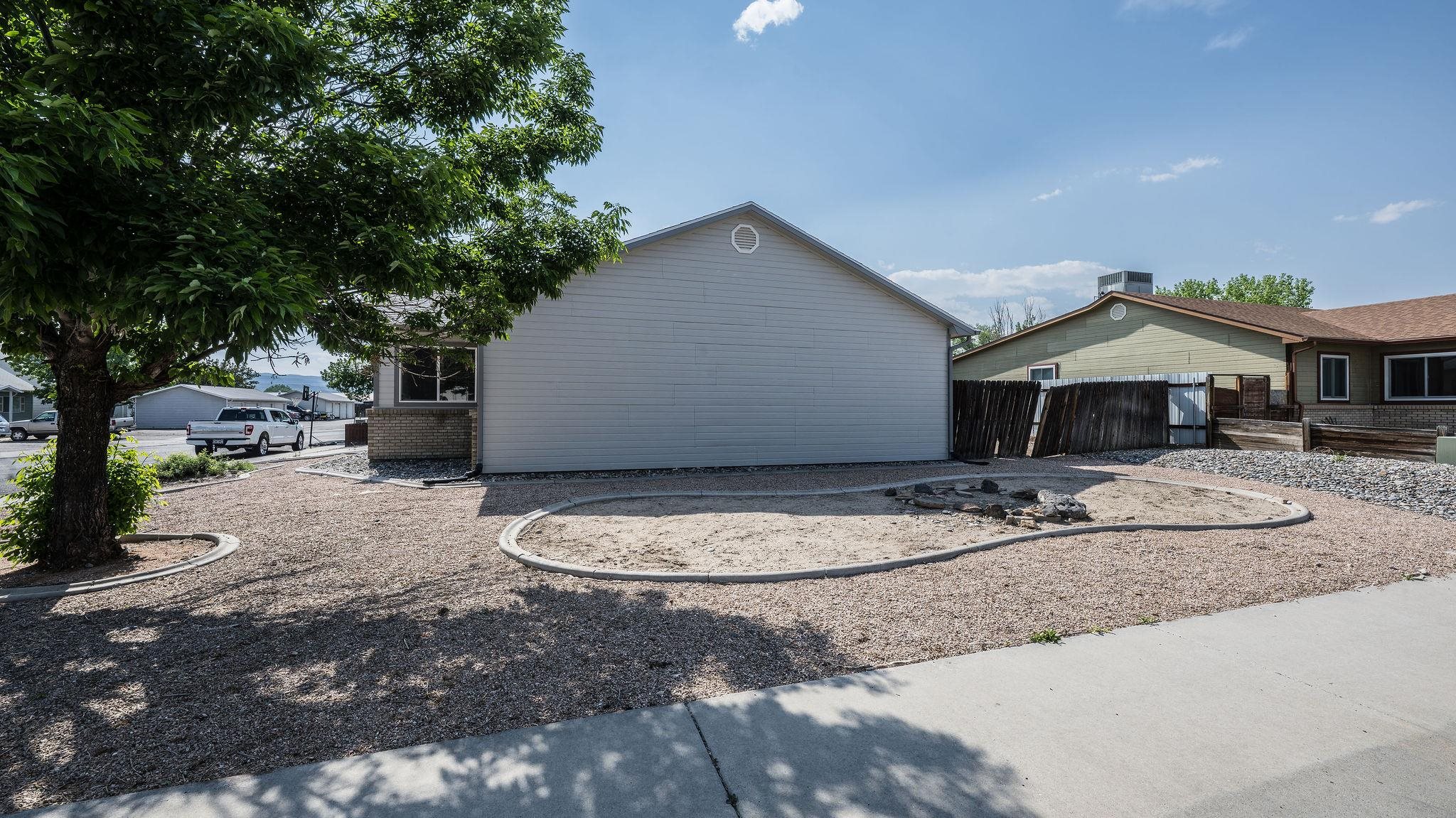 455 David Court Fruita, CO 81521 - Photo 19 of 28 a backyard of a house with yard fire pit and outdoor seating