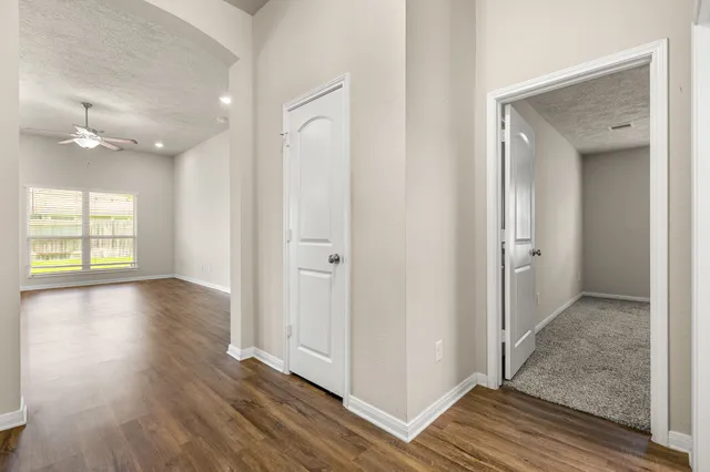 an empty room with wooden floor and windows