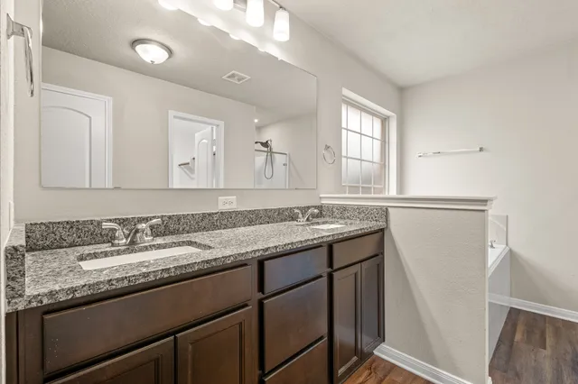 a bathroom with a granite countertop sink and a mirror