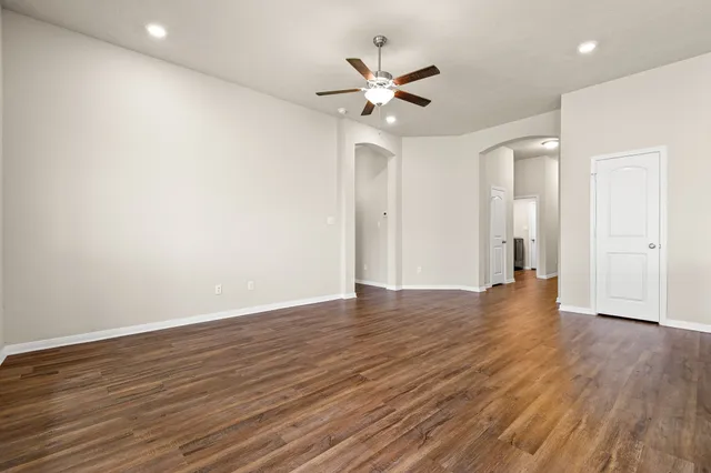 a view of an empty room with wooden floor