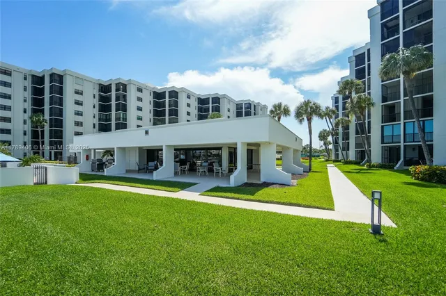 a view of a house with a big yard and large trees