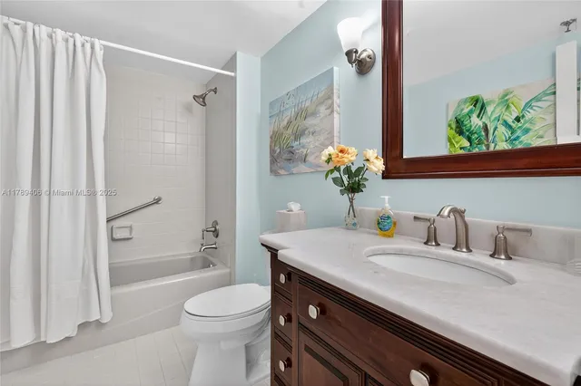 a bathroom with a granite countertop sink a toilet and shower