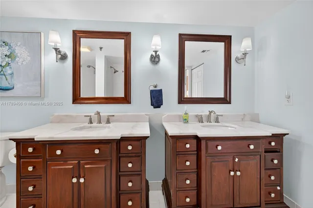 a bathroom with double sink and two mirror