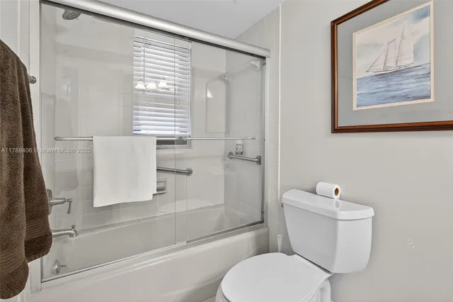 a white toilet sitting next to a bath tub shower