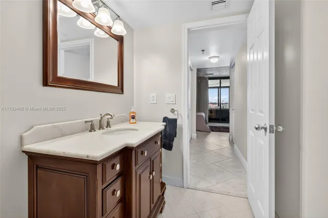 a en suite bathroom with a granite countertop sink and a mirror