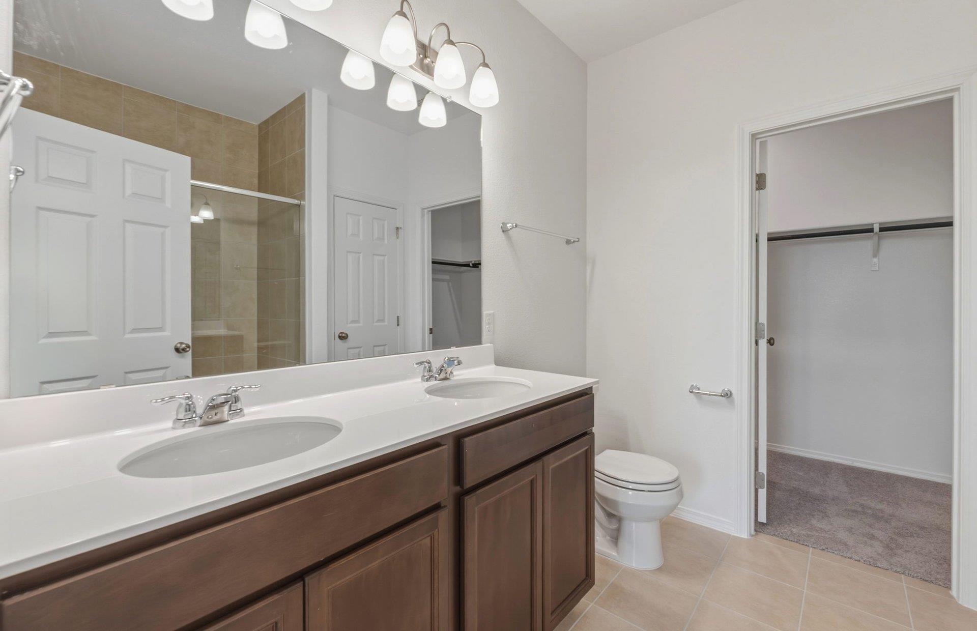 545 Henry Milton Road Georgetown, TX 78626 - Photo 15 of 33 Double vanities and solid surface countertops create a highly functional primary bath layout.