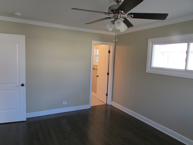 7719 East Prairie Road Skokie, IL 60076 - Photo 20 of 25 an empty room with wooden floor fan and windows