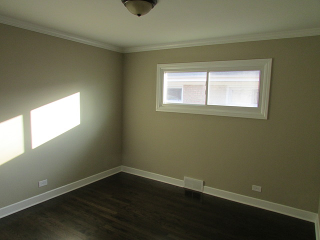 7719 East Prairie Road Skokie, IL 60076 - Photo 22 of 25 an empty room with wooden floor and windows