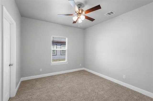 an empty room with a window and a fan