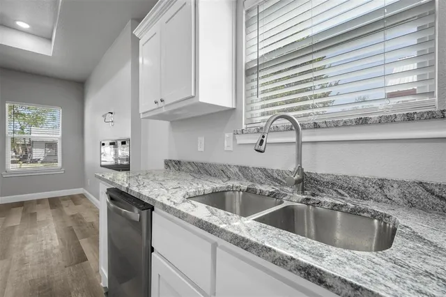 a kitchen with a sink cabinets and window