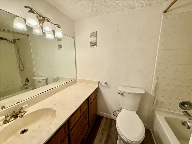 a bathroom with a sink mirror vanity and toilet