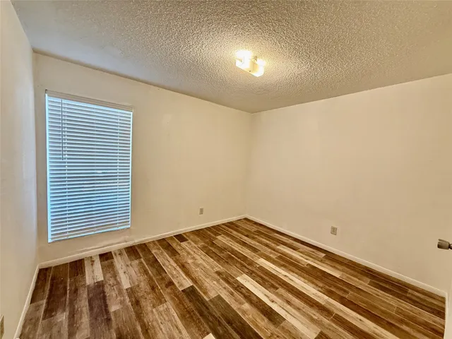 a view of a room with wooden floor and a fan