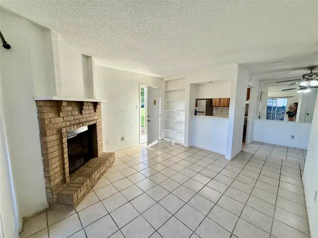 a view of a livingroom with an empty space and a fireplace